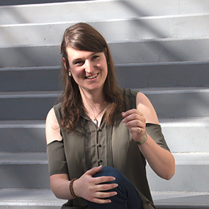 An image of Zachary Howell sitting on a flight of stairs and smiling.