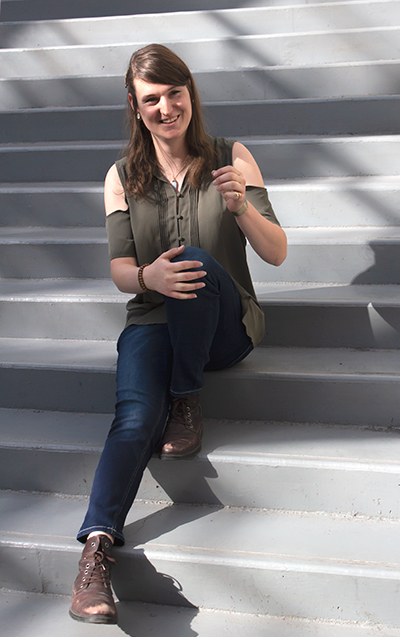 An image of Zachary Howell sitting on a flight of stairs and smiling.
